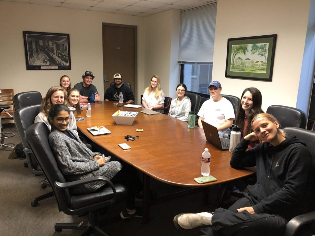 Glass Half Full Nola Founder meeting with the GCSP Scholars around a table at Tulane SSE Dean's Office Conference Room
