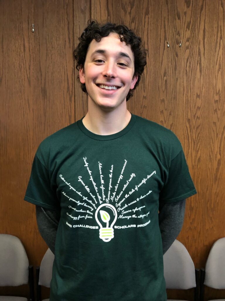 Male Tulane student Sam Kosiborod smiles for the photo in his Grand Challenges T-shirt