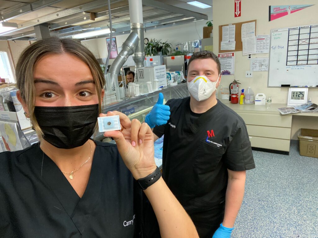 Camryn and colleague posing with a microscope slide sample.