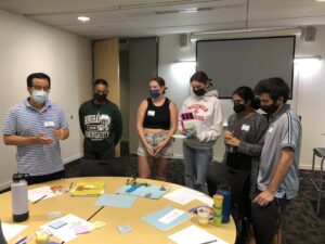 GCSP Scholars standing and presenting their ideas from the Fall 2021 workshop retreat